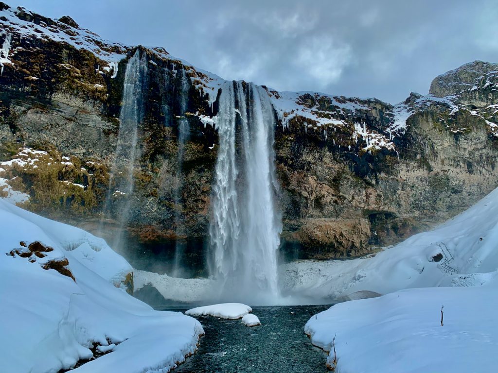 waterfalls in the middle of snow covered mountain