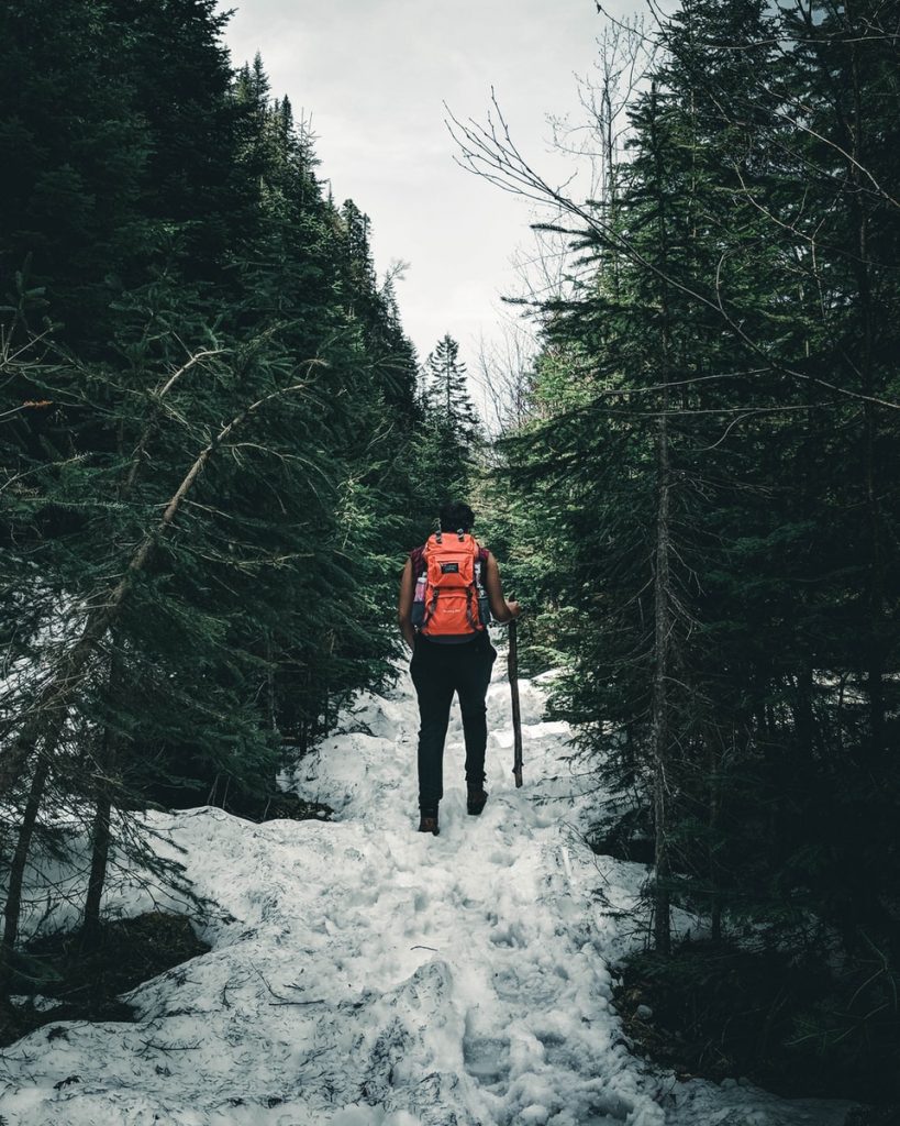 person in red jacket standing on snow covered ground